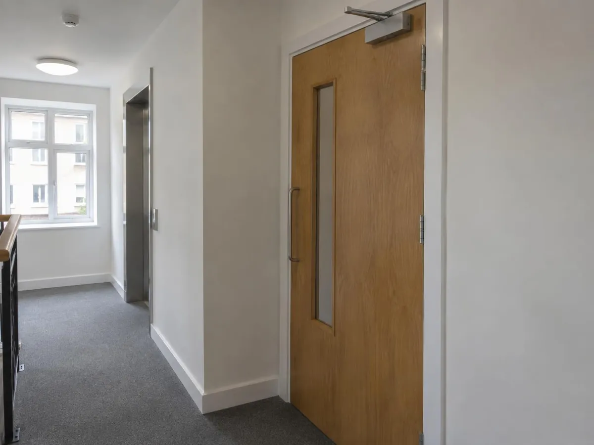 Fire door with a self-closing device in a communal corridor